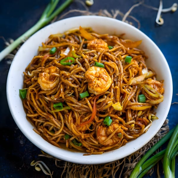 Himalayan Grill's shrimp noodles with vegetables and green onions in a white bowl.