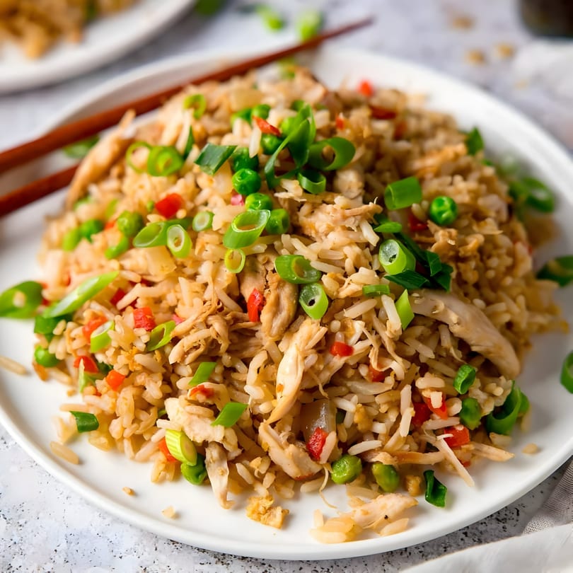 Himalayan Grill's chicken fried rice with peas, red peppers, and green onions, with chopsticks.